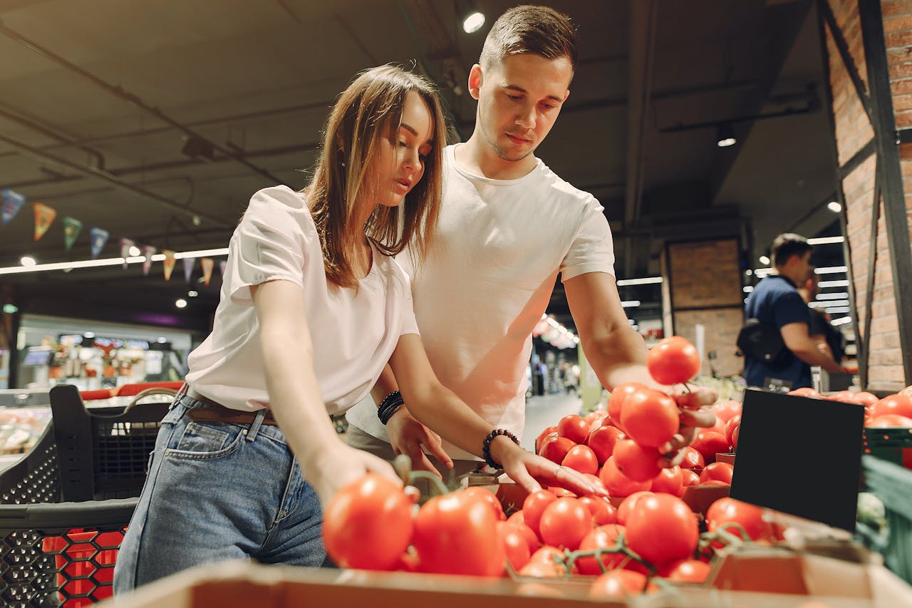 portfolio-04 A couple selecting fresh tomatoes in a modern grocery store, promoting healthy living.