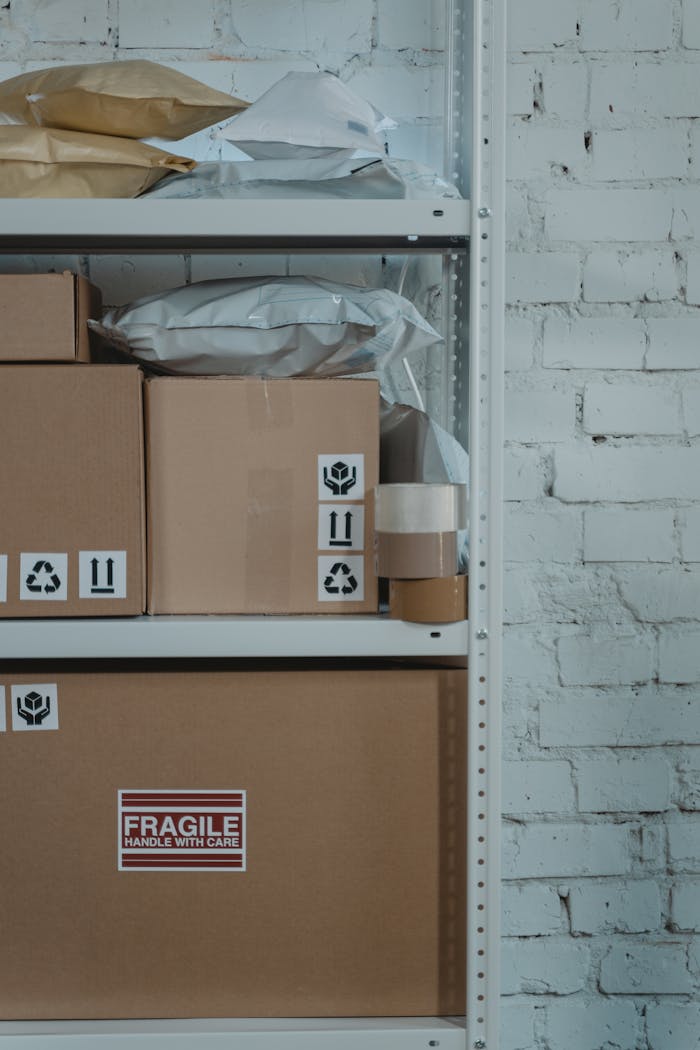 stats-img A warehouse shelf with labeled cardboard boxes and packing materials against a brick wall.